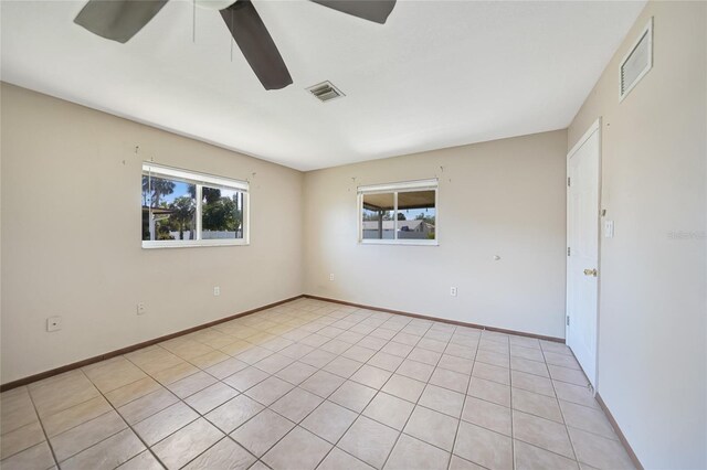 empty room with visible vents, baseboards, and a ceiling fan