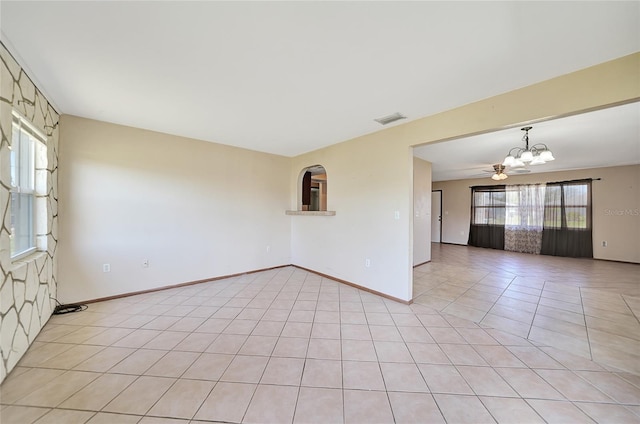 empty room featuring a notable chandelier, visible vents, baseboards, and light tile patterned flooring