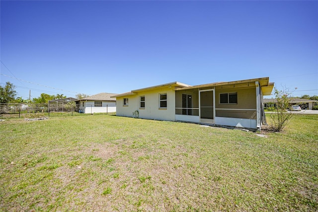 back of house with a sunroom, a yard, and fence