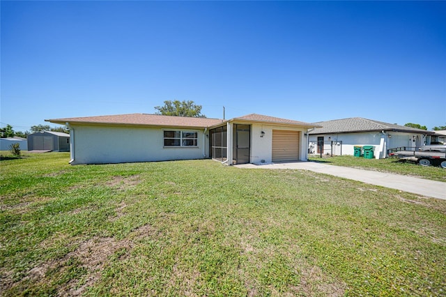 ranch-style house with a front yard, stucco siding, a garage, driveway, and a storage unit