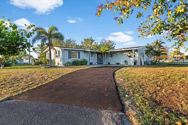 ranch-style house with driveway and board and batten siding