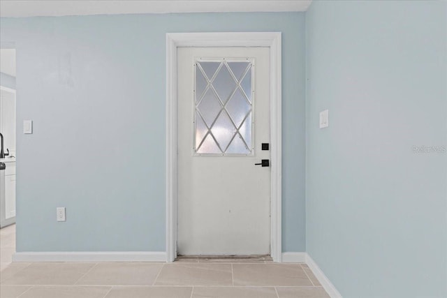 doorway to outside with light tile patterned floors and baseboards