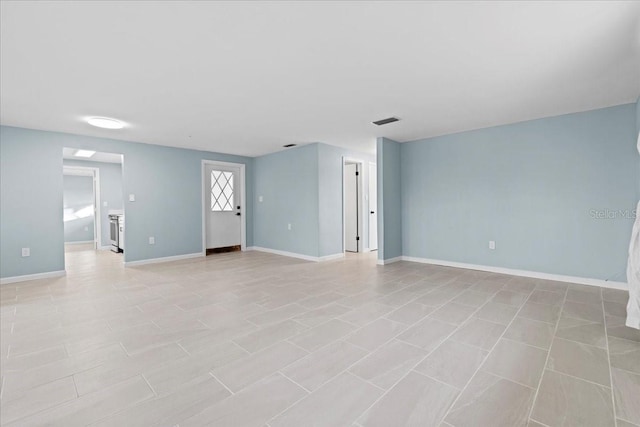 unfurnished living room featuring baseboards and visible vents