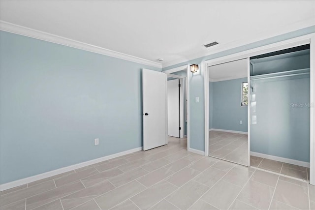 unfurnished bedroom featuring light tile patterned flooring, a closet, crown molding, baseboards, and visible vents