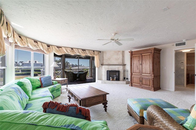 living room featuring light carpet, a textured ceiling, a healthy amount of sunlight, and ceiling fan