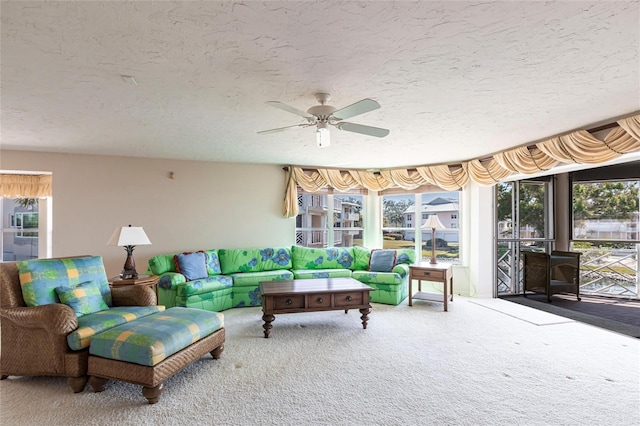 carpeted living room with a wealth of natural light, a textured ceiling, and a ceiling fan