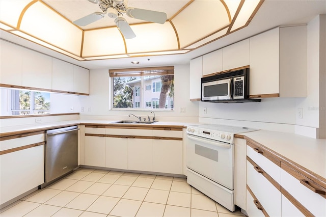 kitchen featuring a sink, stainless steel appliances, ceiling fan, and light countertops