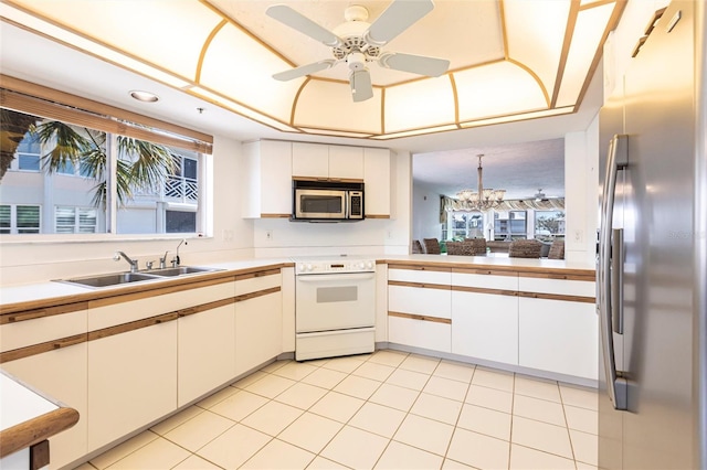 kitchen with a sink, stainless steel appliances, a wealth of natural light, and white cabinets