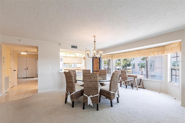 dining area featuring a textured ceiling, a notable chandelier, visible vents, and light carpet