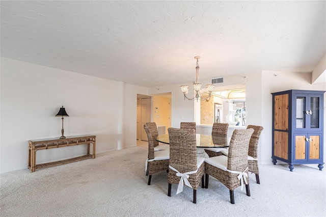 carpeted dining space featuring visible vents, a textured ceiling, and an inviting chandelier