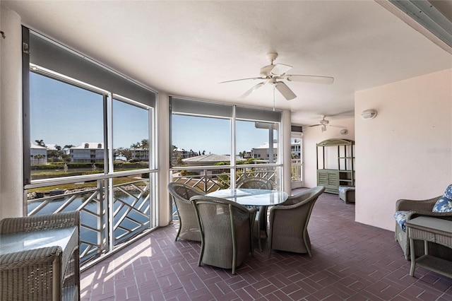 sunroom / solarium featuring plenty of natural light and a ceiling fan