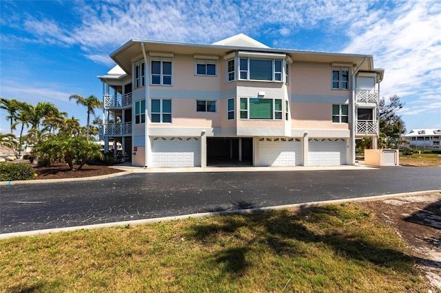 view of front of property featuring stucco siding, an attached garage, and aphalt driveway