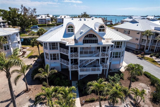 exterior space with metal roof, a water view, and a sunroom