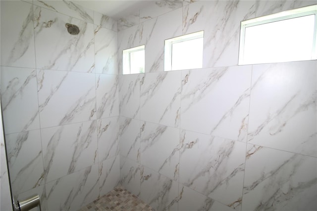 full bathroom with stone wall and a tile shower