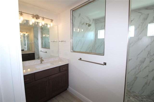 full bathroom featuring vanity, baseboards, and a marble finish shower