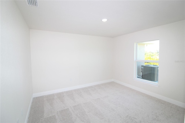 spare room featuring visible vents, carpet, and baseboards