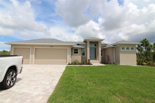 9529 Calumet Blvd, Port Charlotte, FL 33981 - prairie-style house featuring stucco siding, a garage, decorative driveway, and a front lawn