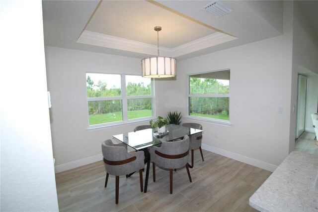 9529 Calumet Blvd, Port Charlotte, FL 33981 - dining space with a tray ceiling, plenty of natural light, light wood-style floors, and crown molding