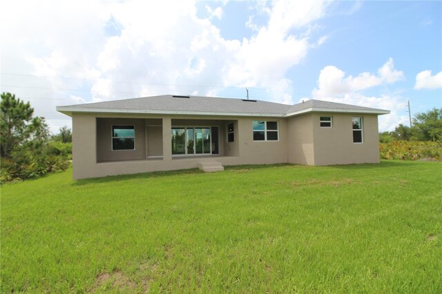 9529 Calumet Blvd, Port Charlotte, FL 33981 - rear view of house with stucco siding and a yard