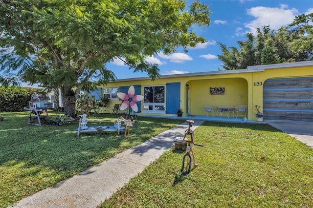 view of front of property featuring stucco siding, a garage, and a front lawn