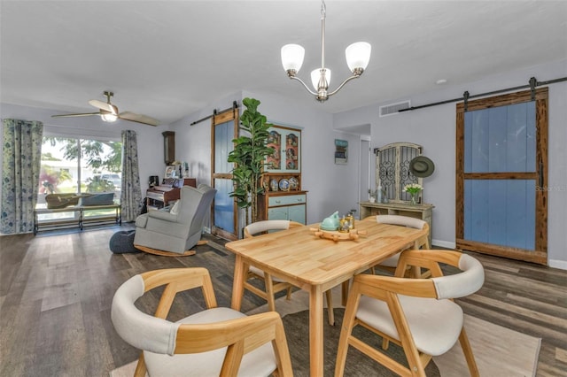 dining room with wood finished floors, visible vents, baseboards, a barn door, and ceiling fan with notable chandelier