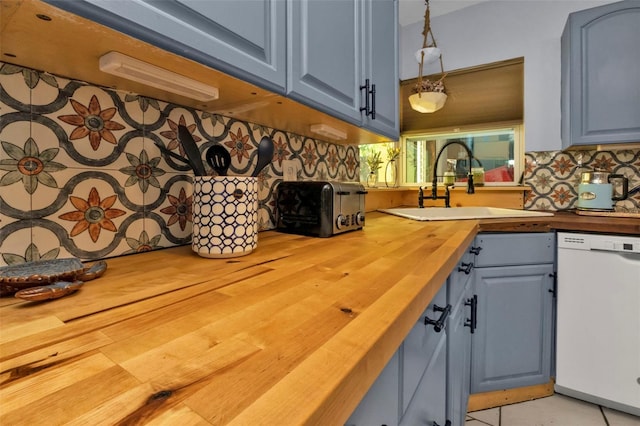 kitchen with a sink, blue cabinets, wooden counters, and dishwasher