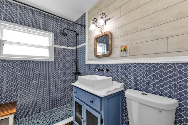 full bath with toilet, vanity, and a tile shower