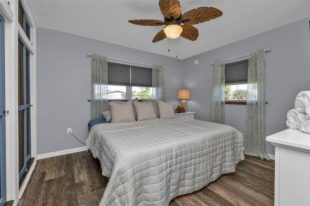 bedroom featuring ceiling fan, baseboards, multiple windows, and wood finished floors