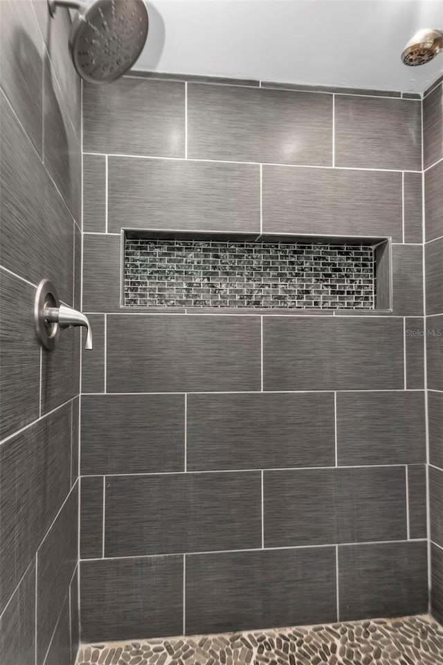 full bath featuring tiled shower