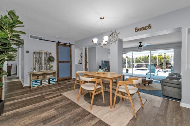 dining area featuring a barn door, wood finished floors, visible vents, and baseboards