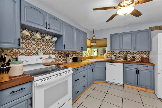 kitchen featuring wooden counters, white appliances, a ceiling fan, and a sink