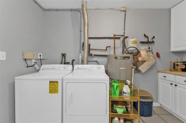 clothes washing area featuring light tile patterned flooring, cabinet space, electric water heater, and separate washer and dryer