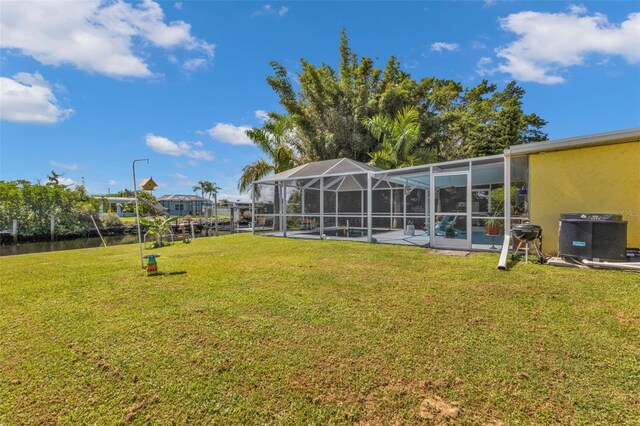 view of yard with a swimming pool, central AC, and a lanai