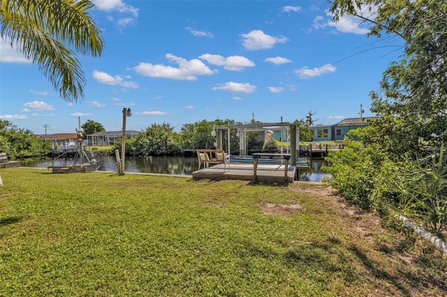 view of yard featuring a dock, a water view, and boat lift