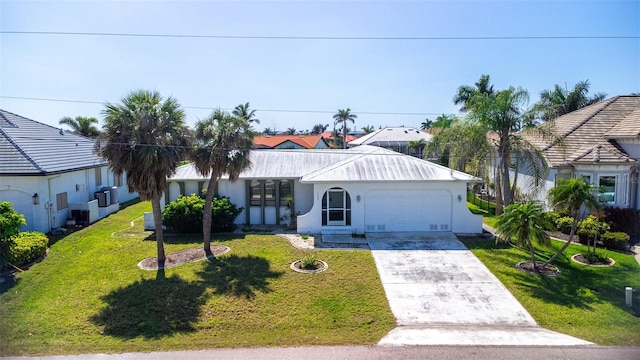 view of front of property featuring a front lawn, stucco siding, metal roof, a garage, and driveway