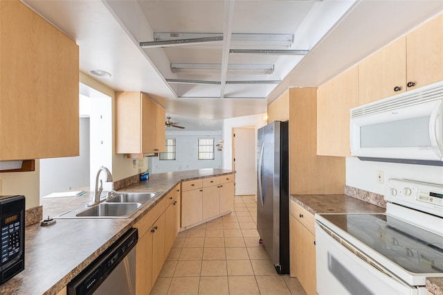 kitchen with light tile patterned floors, light brown cabinets, a peninsula, a sink, and stainless steel appliances