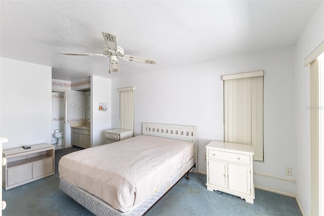 carpeted bedroom featuring baseboards, a textured ceiling, ensuite bathroom, and a ceiling fan