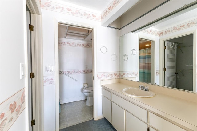 bathroom featuring wallpapered walls, toilet, and vanity