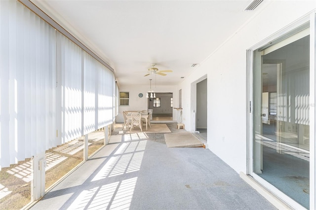 unfurnished sunroom featuring visible vents and ceiling fan