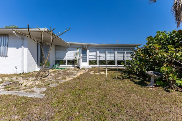 back of house with a yard and stucco siding