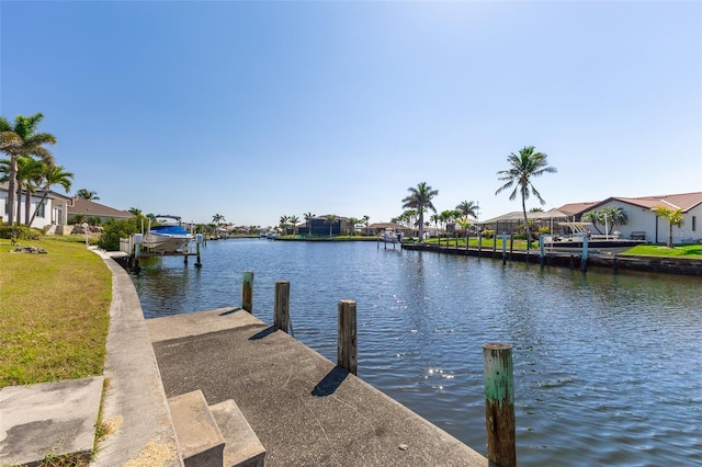 dock area with a residential view, a lawn, and a water view