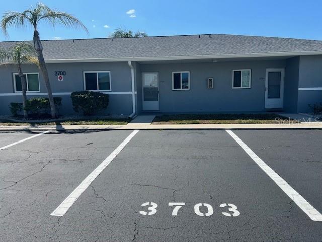 12274 SW Egret Cir Unit 3703, Lake Suzy, FL 34269 - view of front facade featuring uncovered parking, stucco siding, and a shingled roof