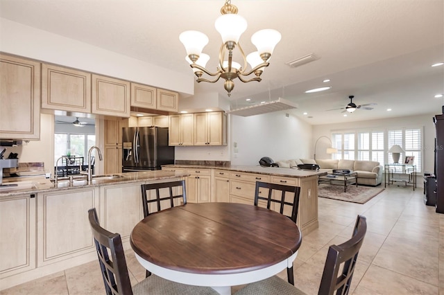 dining area featuring light tile patterned flooring, plenty of natural light, ceiling fan with notable chandelier, and recessed lighting