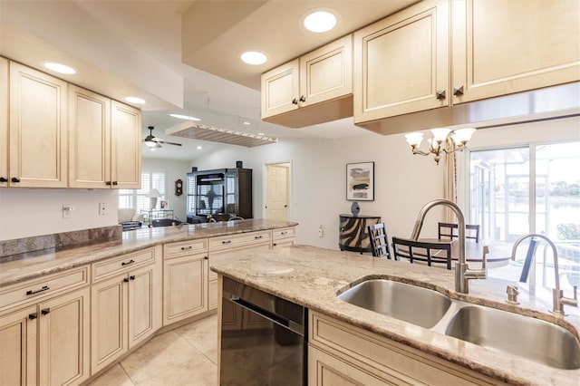 kitchen featuring black dishwasher, ceiling fan with notable chandelier, a peninsula, cream cabinets, and a sink