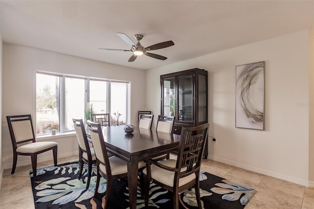 dining area featuring a ceiling fan and baseboards