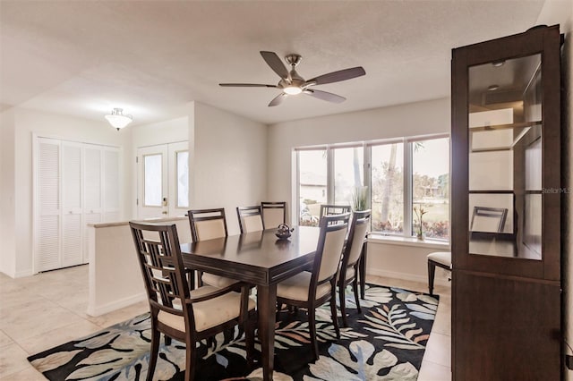 dining room with light tile patterned floors, baseboards, and ceiling fan