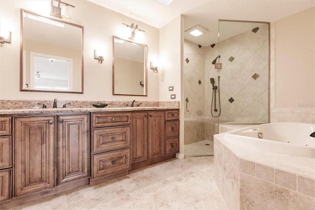 full bathroom featuring a sink, a jetted tub, a stall shower, and double vanity