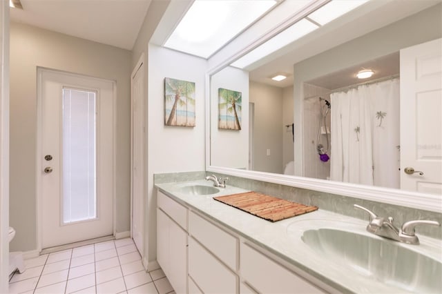 full bathroom with tile patterned flooring, double vanity, toilet, and a sink