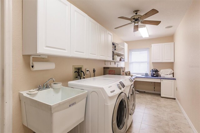 clothes washing area featuring a ceiling fan, baseboards, washing machine and clothes dryer, cabinet space, and a sink