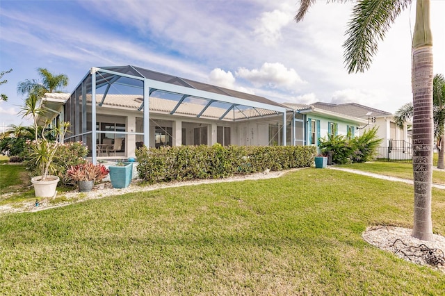 back of house featuring a lanai and a yard